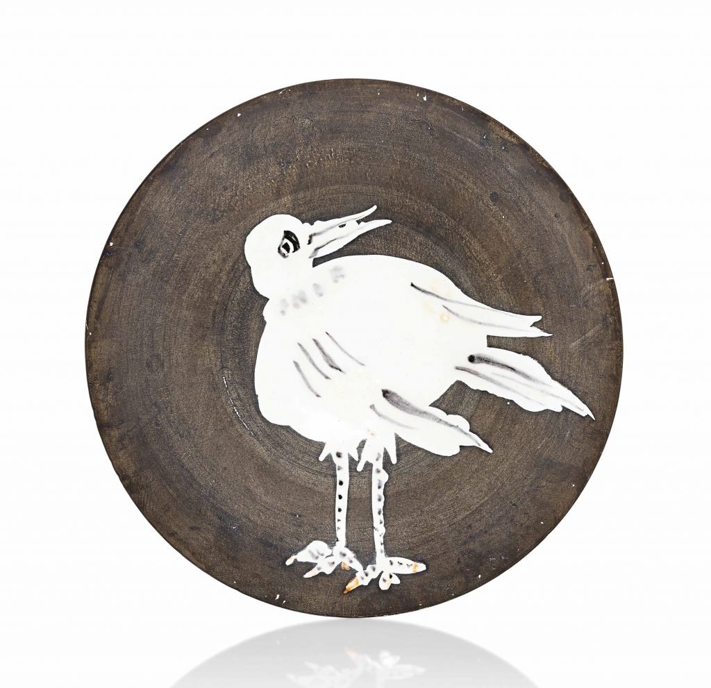 From Pablo Picasso Ceramics that is round and glazed brown save for the outline drawing of a white seagull in the center.