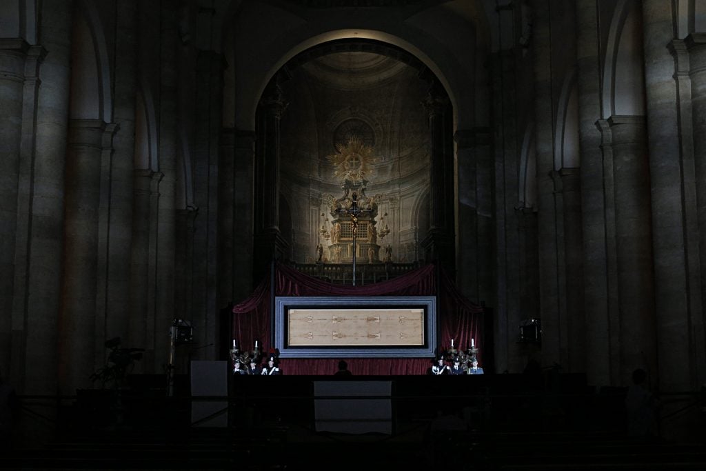 The Shroud of Turin on display in a dark cathedral