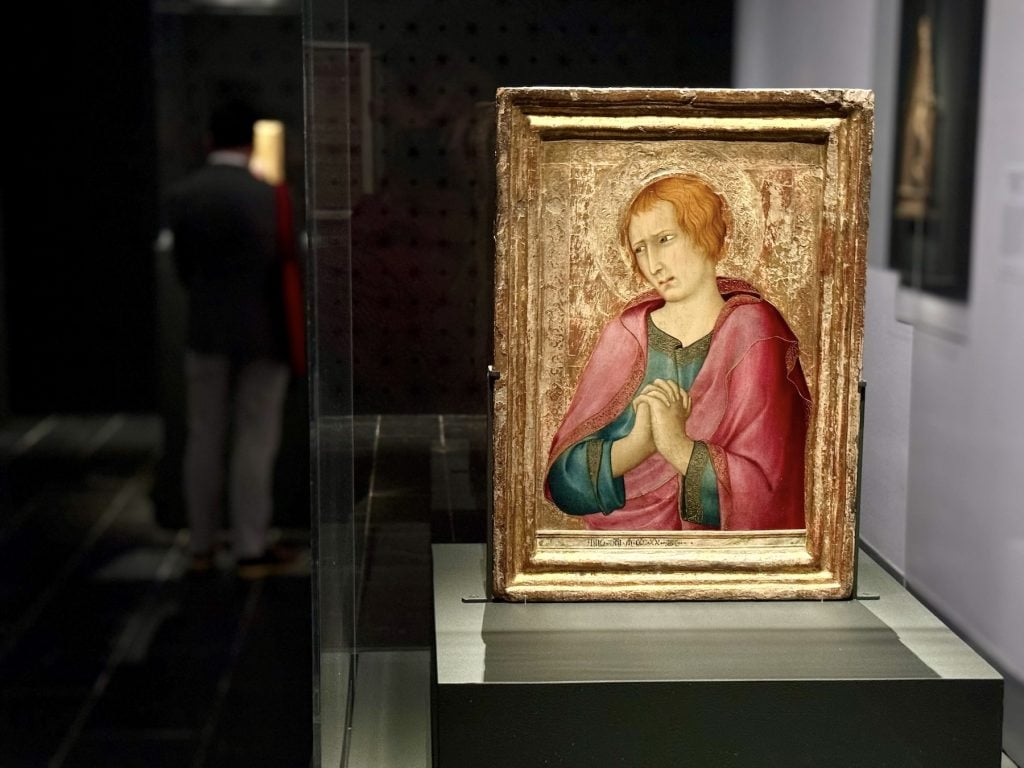 An image of a man praying displayed in an art gallery