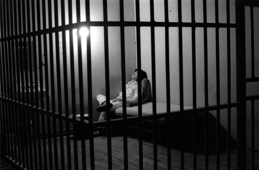 A Taiwanese man sits in what appears to be a jail cell