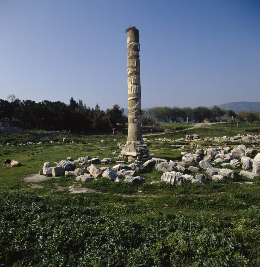 An ancient column standing alone in a field of stones