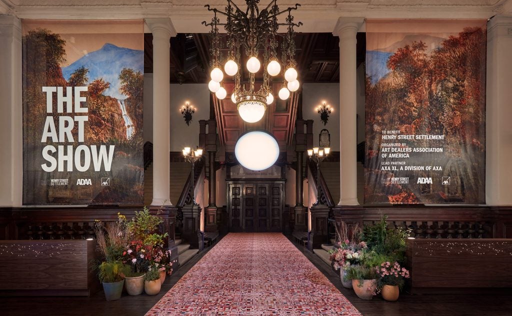 Entrance at the park avenue armory with the art show banners and a large victorian chandelier in the hall.