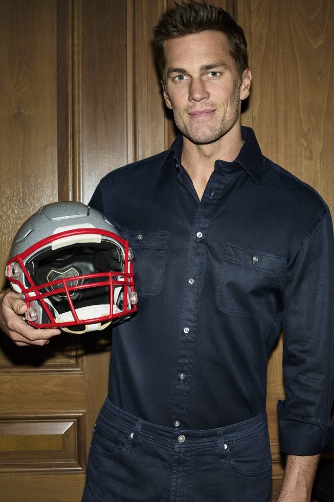 Football player Tom Brady poses with a helmet