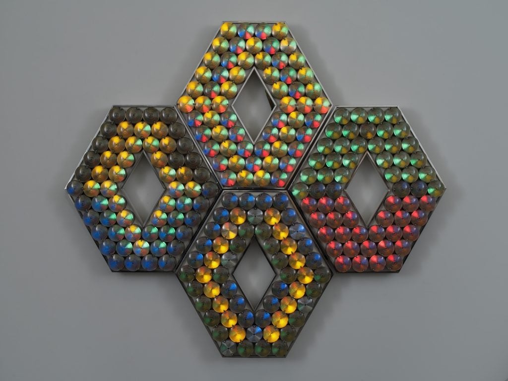 A sculpture made of four diamond shapes, with light bulbs embedded in various colors