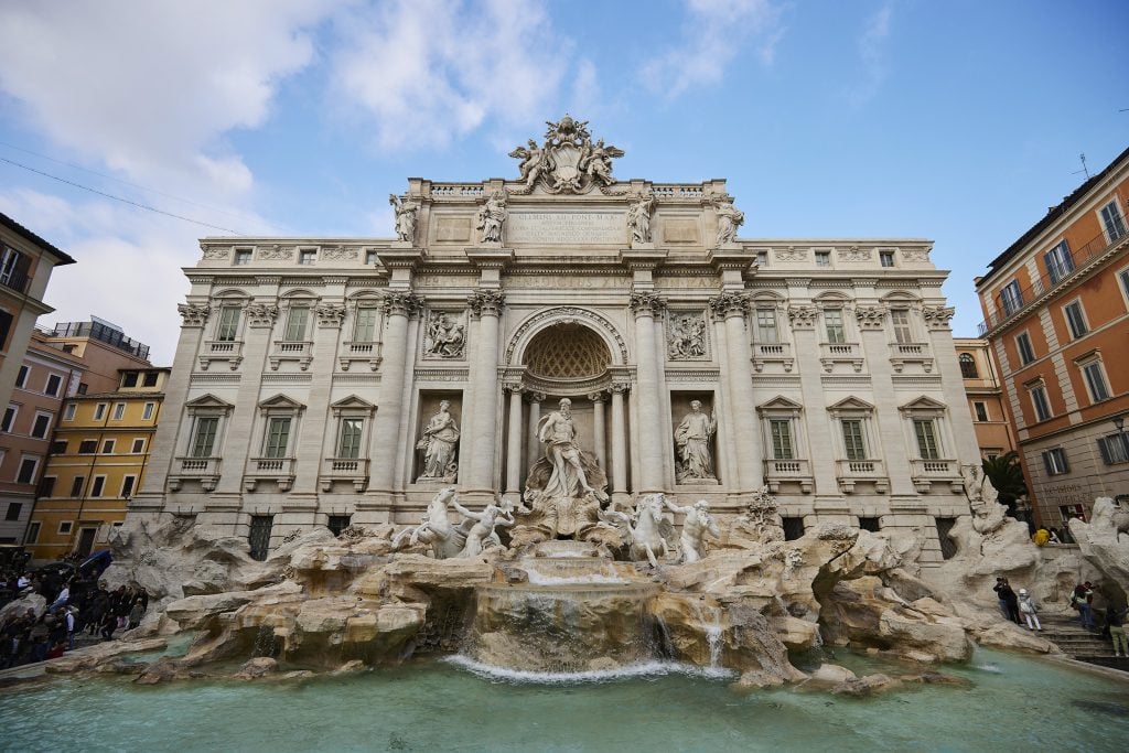 Trevi Fountain in Rome, showcasing its grand architecture and intricate sculptures set against a clear sky