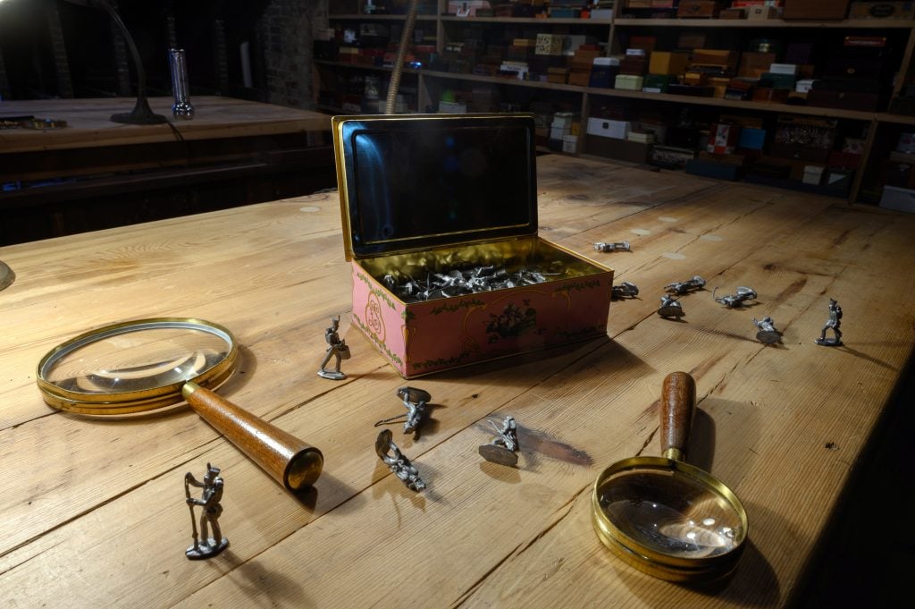 a close up photograph of a wooden table littered with small toy soldiers