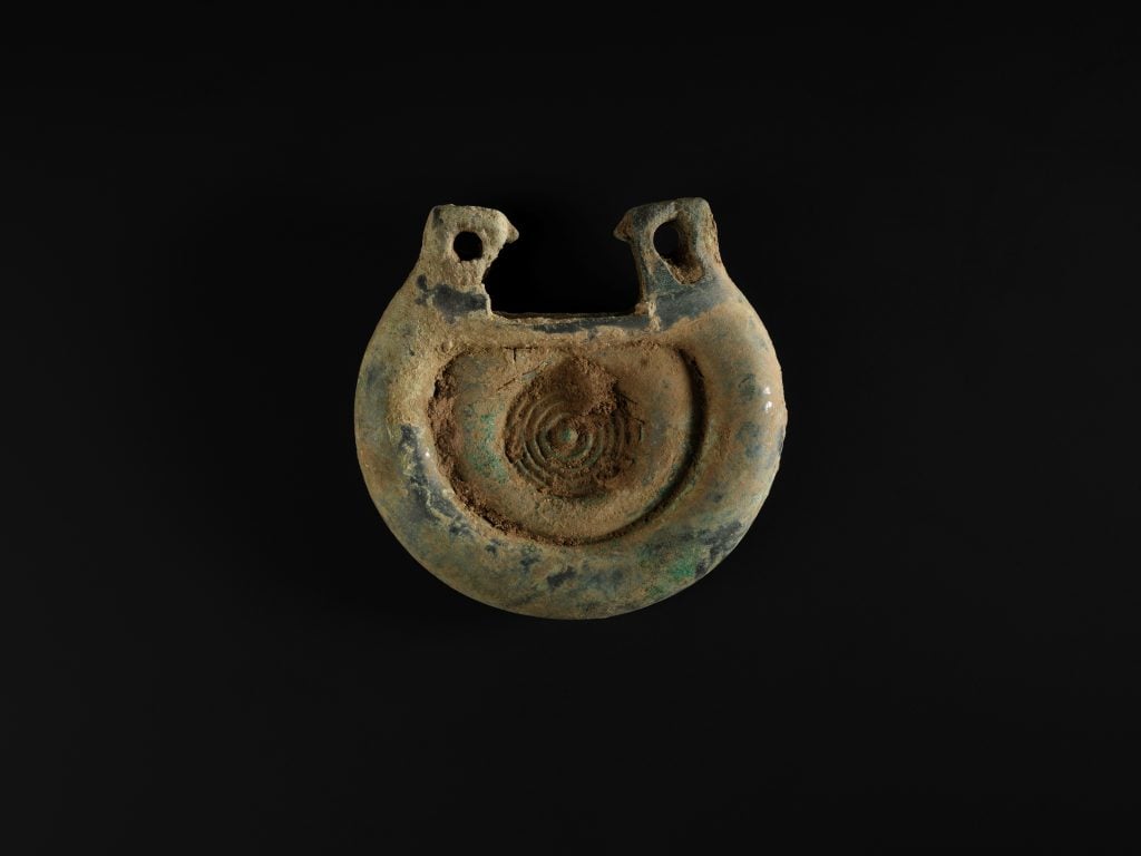 A decorated bronze fitting from the Bronze Age Peebles Hoard. The object is slightly patinated but in otherwise incredible condition.