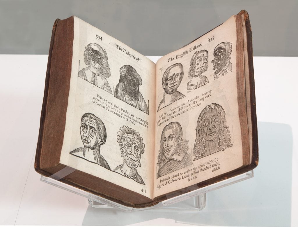 a very old fashioned book shown open on one page with images of people on it