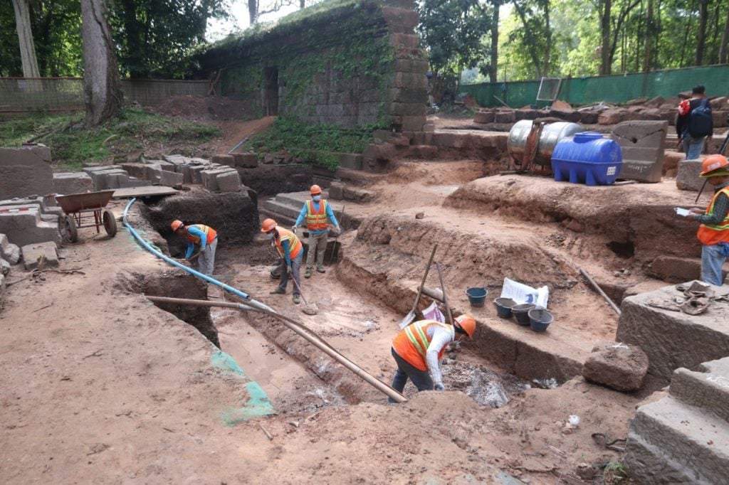 archaeologists at work excavating an expanse of dirt