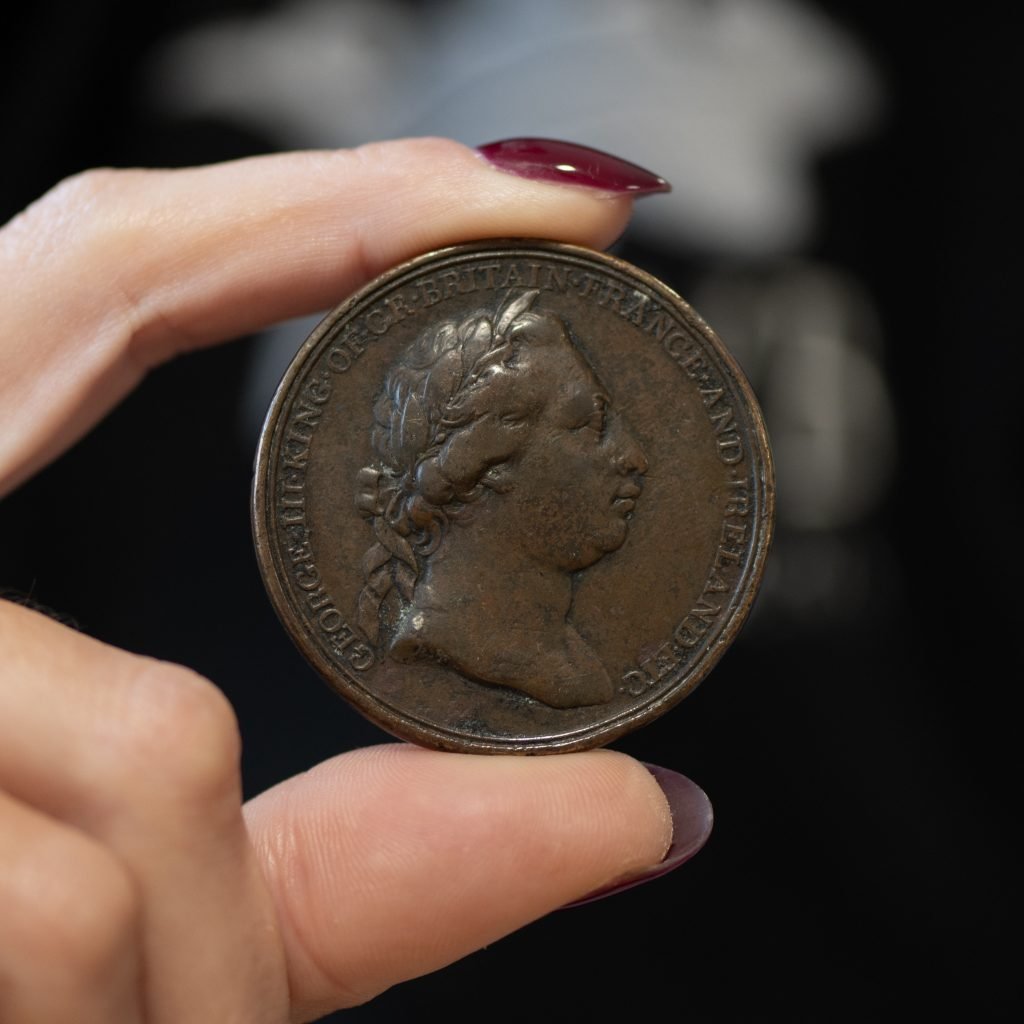 a womans fingers hold a rare coin