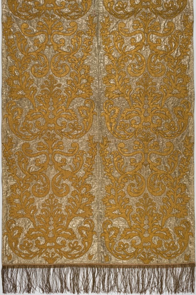 an intricate tapestry is gold with a pattern 