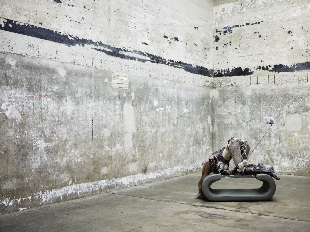 concrete room with a sculpture of a woman taking a selfie from behind at the Boros collection