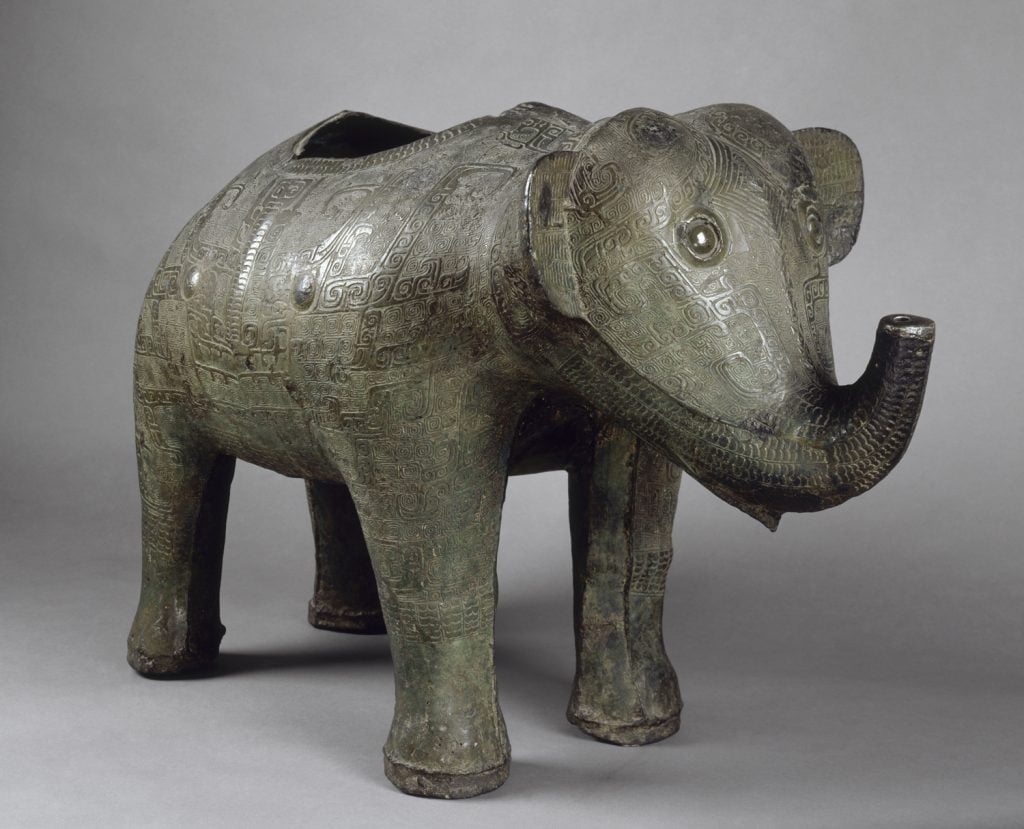 A bronze sculpture of a cute baby elephant that was used as a wine vessel, with a hole on its back