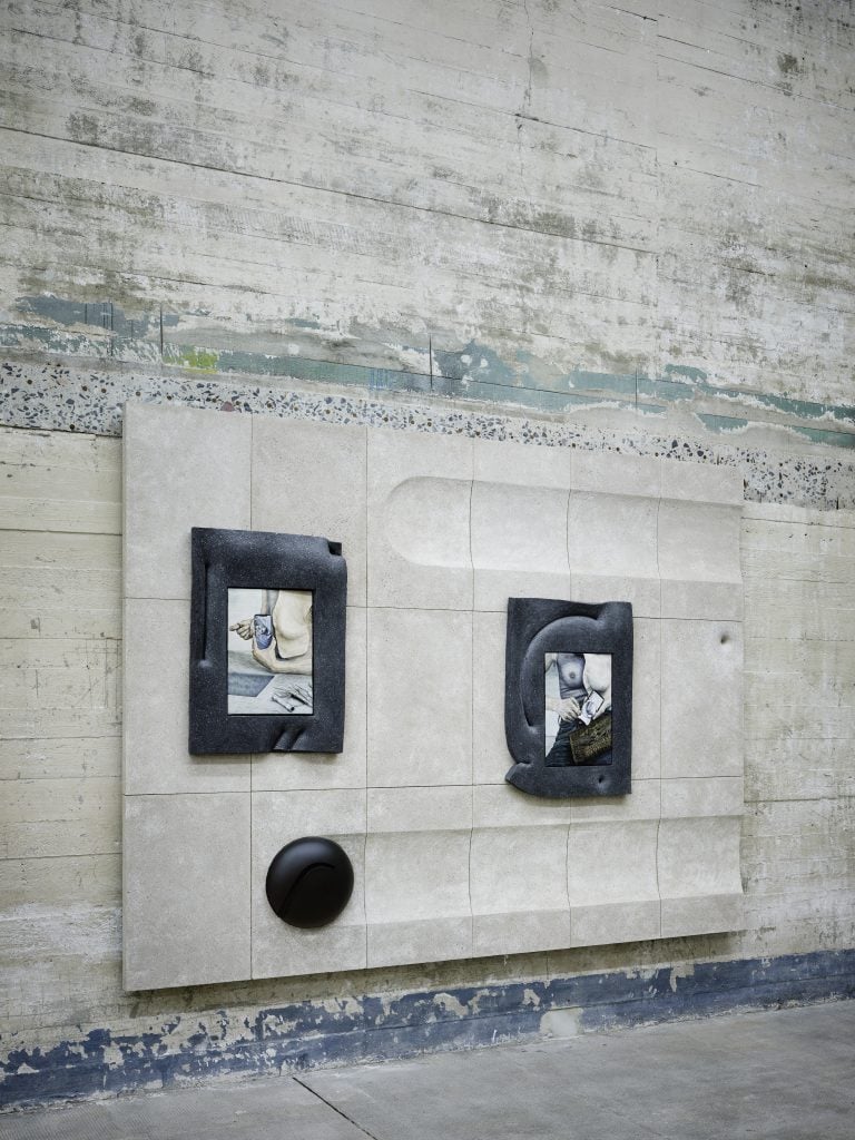 concrete gallery with concrete colored work hung on the wall