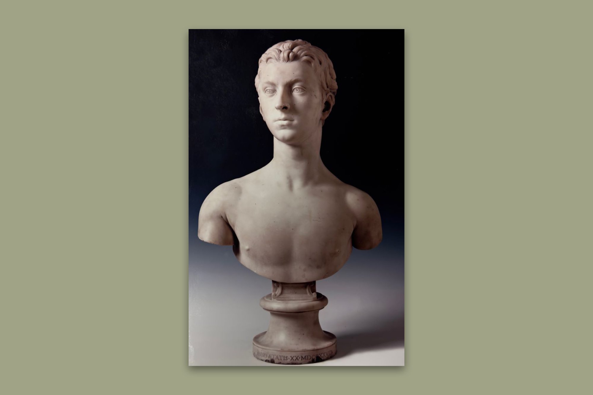 a photograph of a nude marble bust of a young man