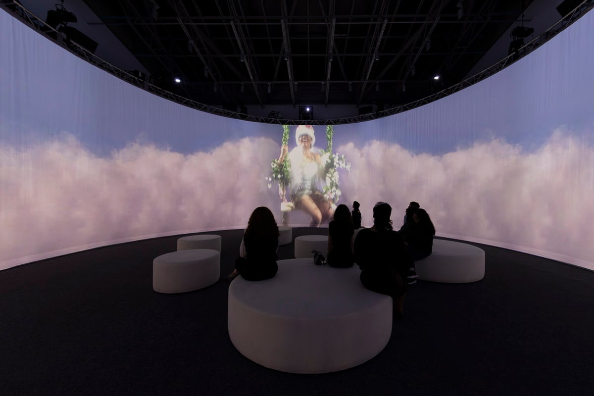 A series of screens show a woman floating atop a cloud