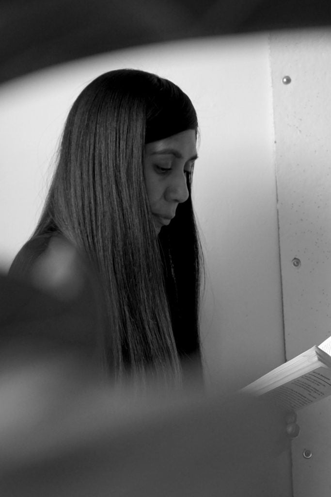 A black and white photo of Carissa Rodriguez, seen in profile from the shoulder up. She is a young woman with long dark hair. .