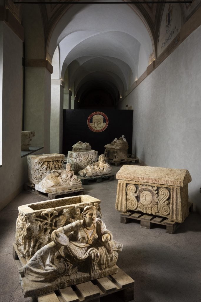 Urns made of Umbrian white travertine and partly decorated in high relief with scenes of battles, hunting and depictions of the myth of Achilles and Troilus, as well as other funerary artifacts.