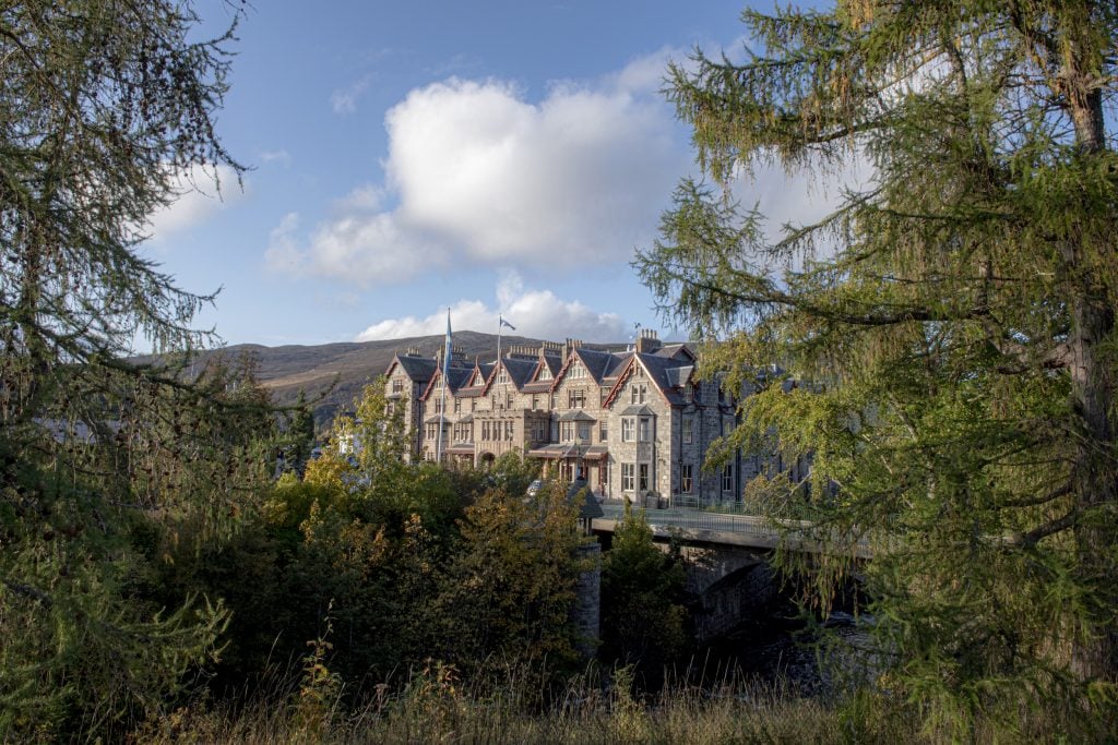 Victorian-style Fife Arms hotel nestled among trees in the scenic Scottish Highlands