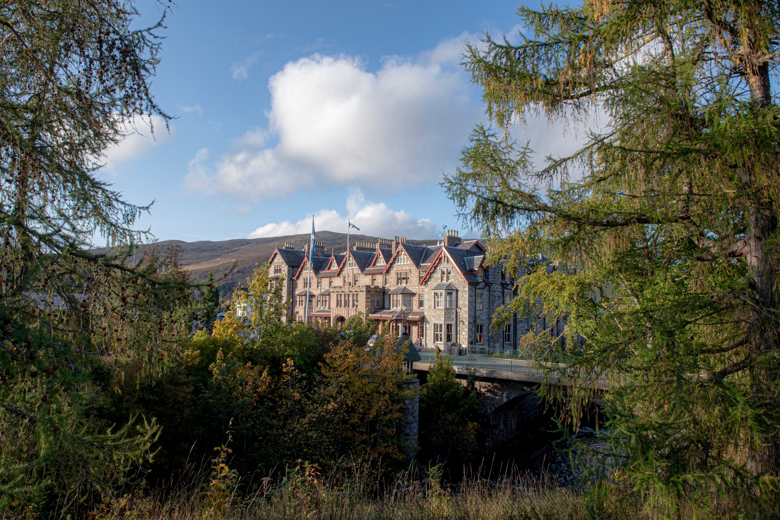 Victorian-style Fife Arms hotel nestled among trees in the scenic Scottish Highlands