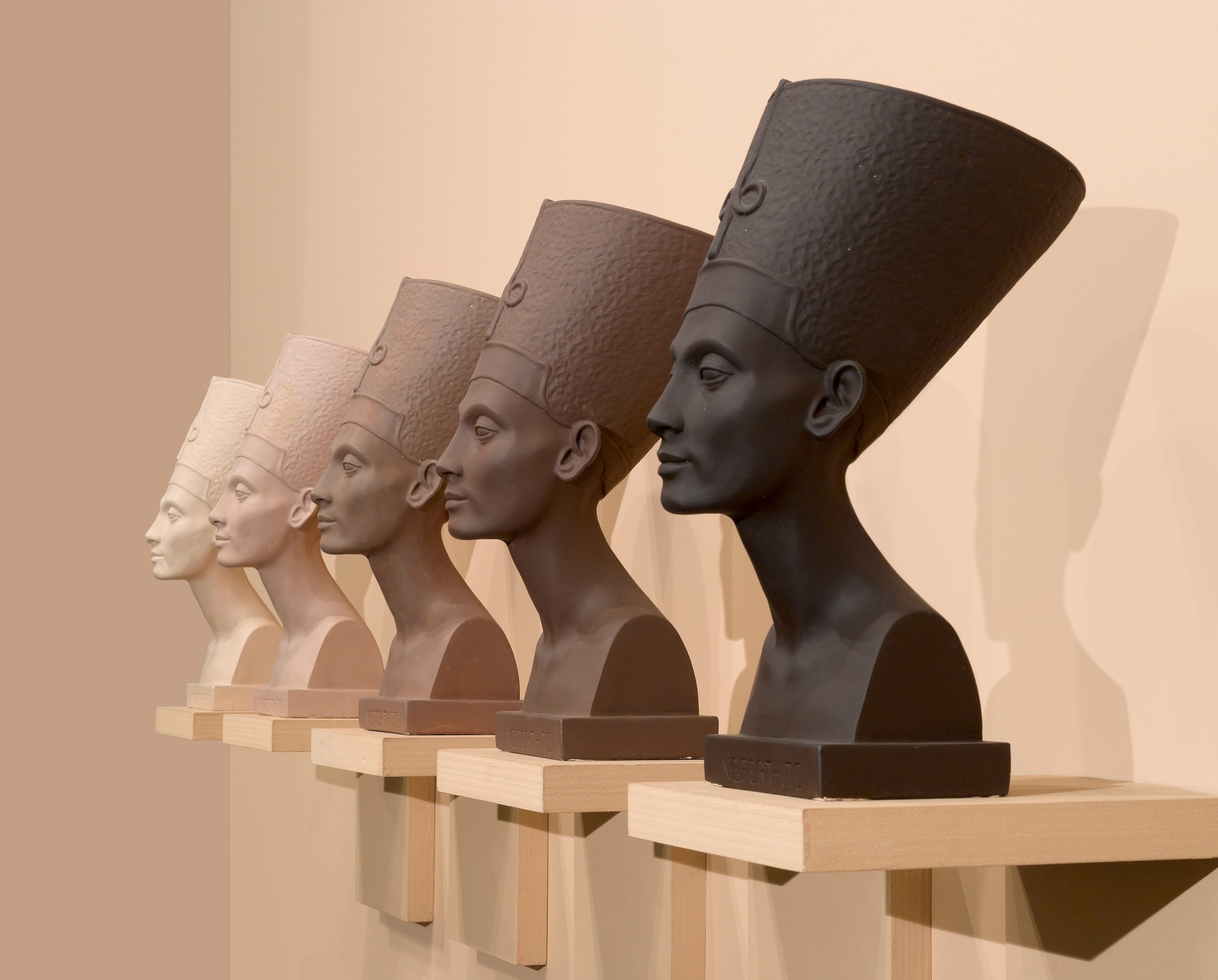 four busts of Nefertiti in various skin tones