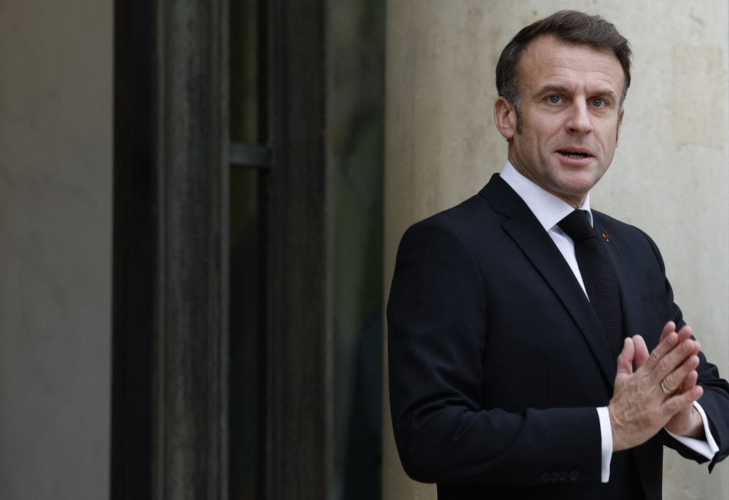 a man in a suit stands outside a building 