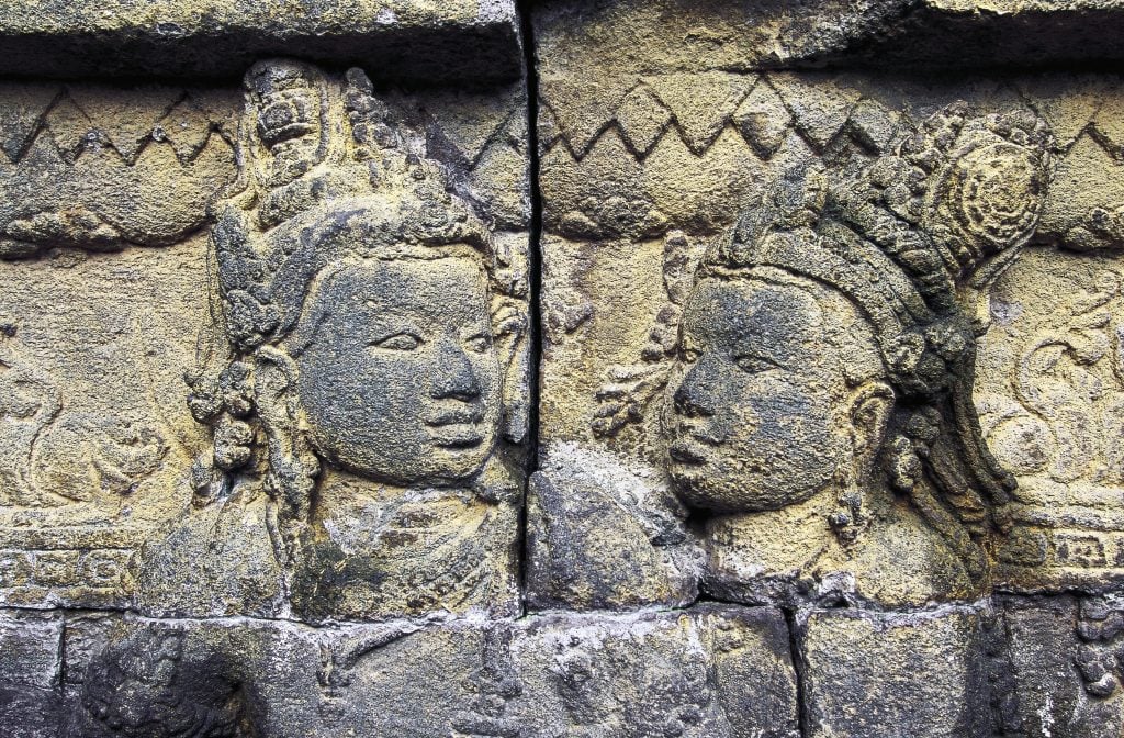 a stone carved relief of two female heads