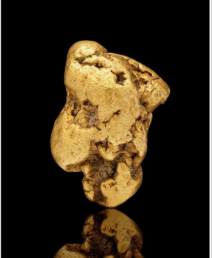 a gold nugget against a black background