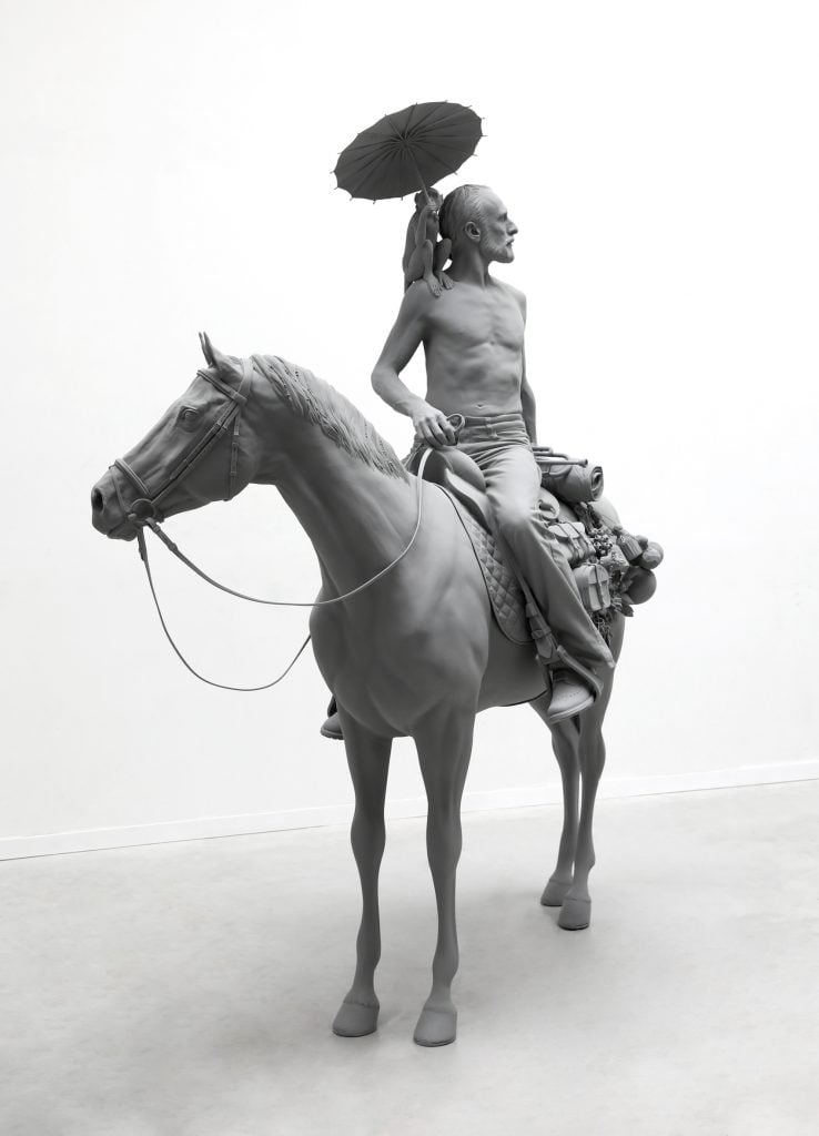 an image of a sculpture of a man on a horse with a monkey on his shoulder turning to look behind him