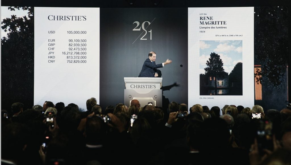 an auctioneer selling a painting by Rene Magritte