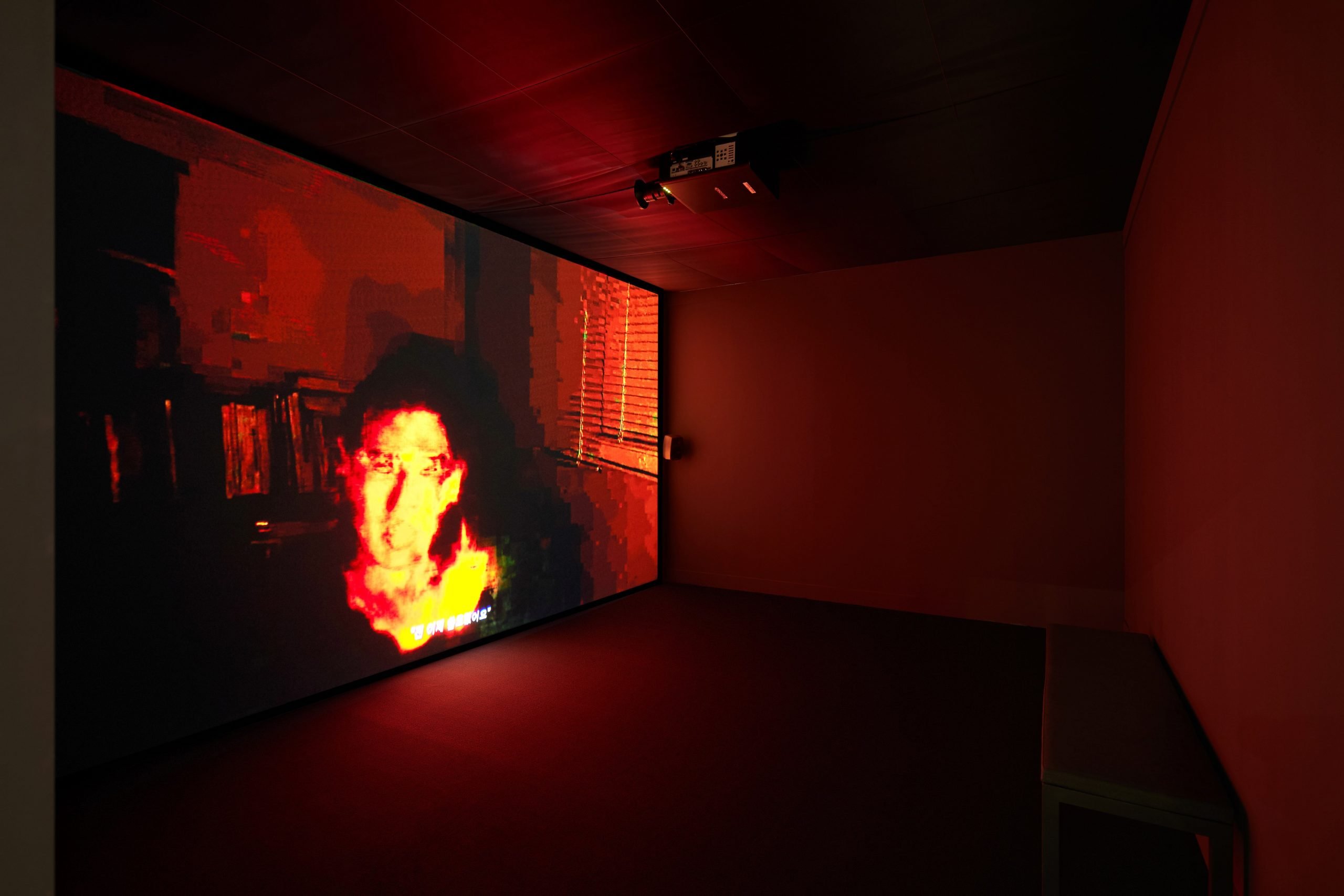 A dimly lit room with a screen showing a video of flames