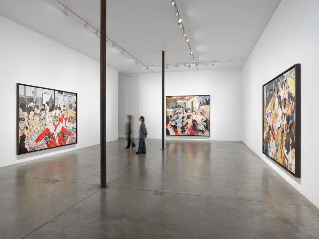 a white-walled gallery features colorful paintings on the walls