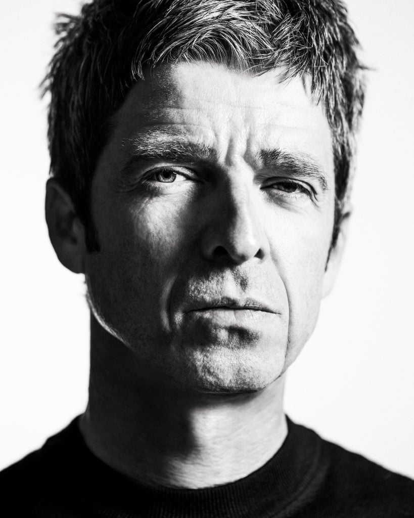 a black and white photograph of Noel Gallagher