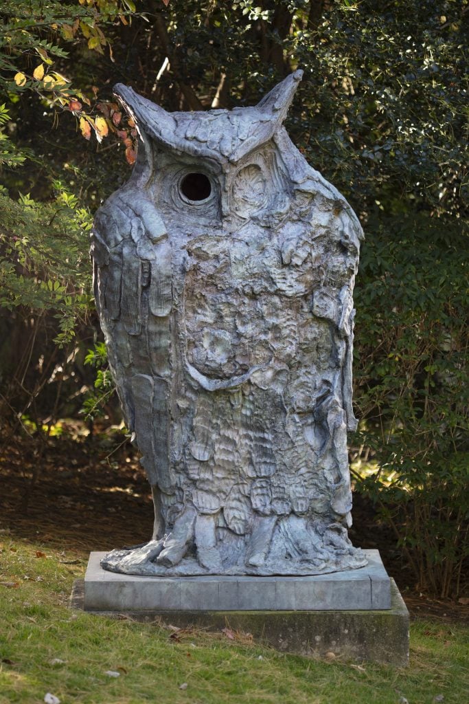 an image of a large bronze statue of an owl with one eye open