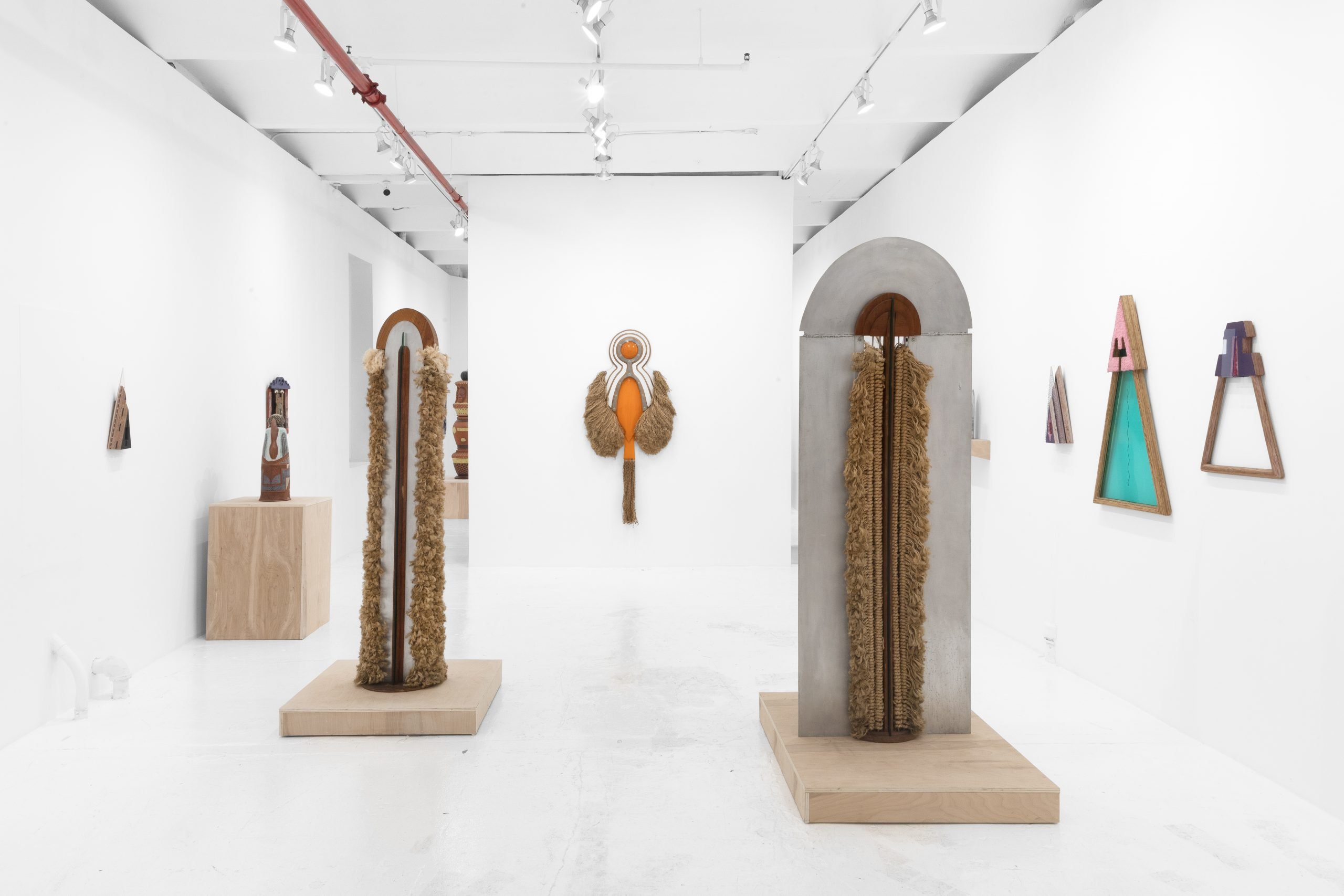 colorful totemic sculptures decorate an art gallery