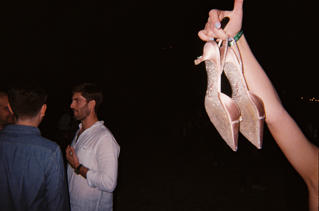 Shoes being held in hands at a party for white cube