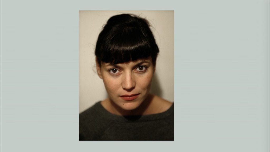 a woman with bangs set against a light blue background