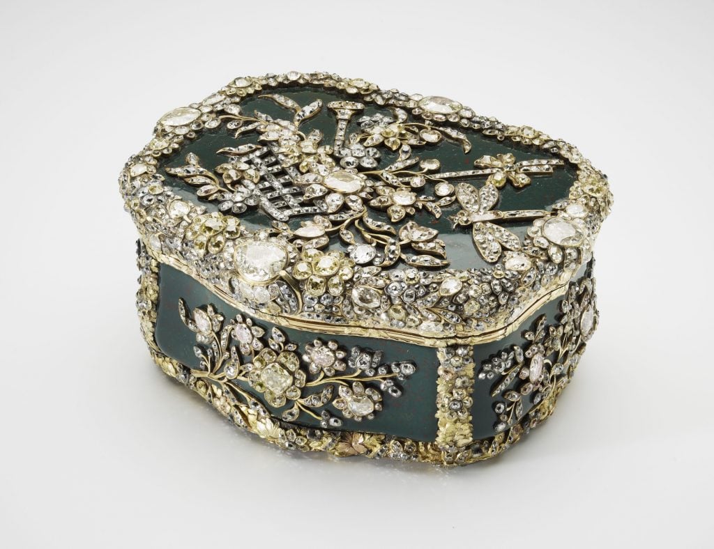 a small jade colored box covered in exquisite bejewelled silver decoration encrusted in diamonds in a foliage design