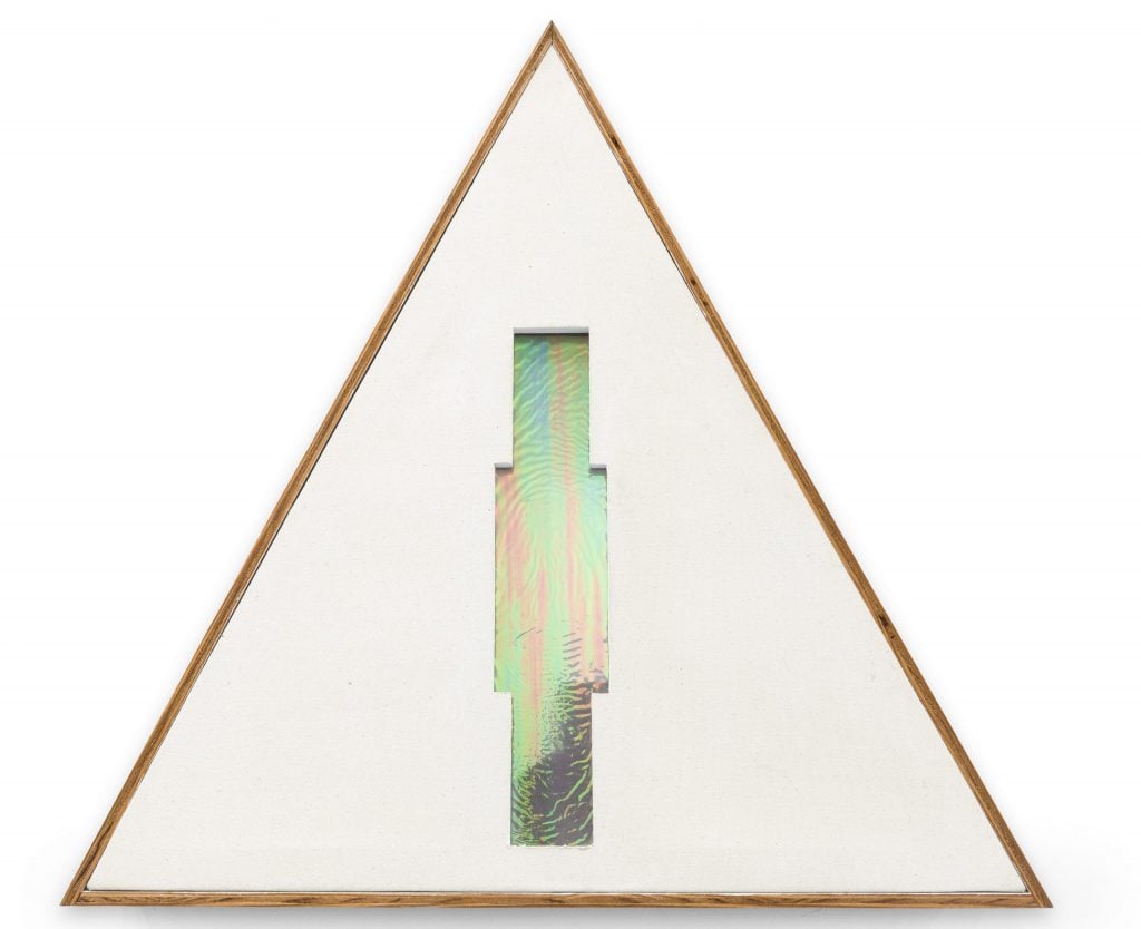 a triangular sculpture has an iridescent design in center 