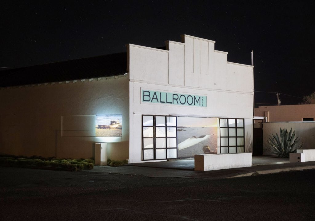 The exterior of a squat Art Deco-style building with the painted sign 