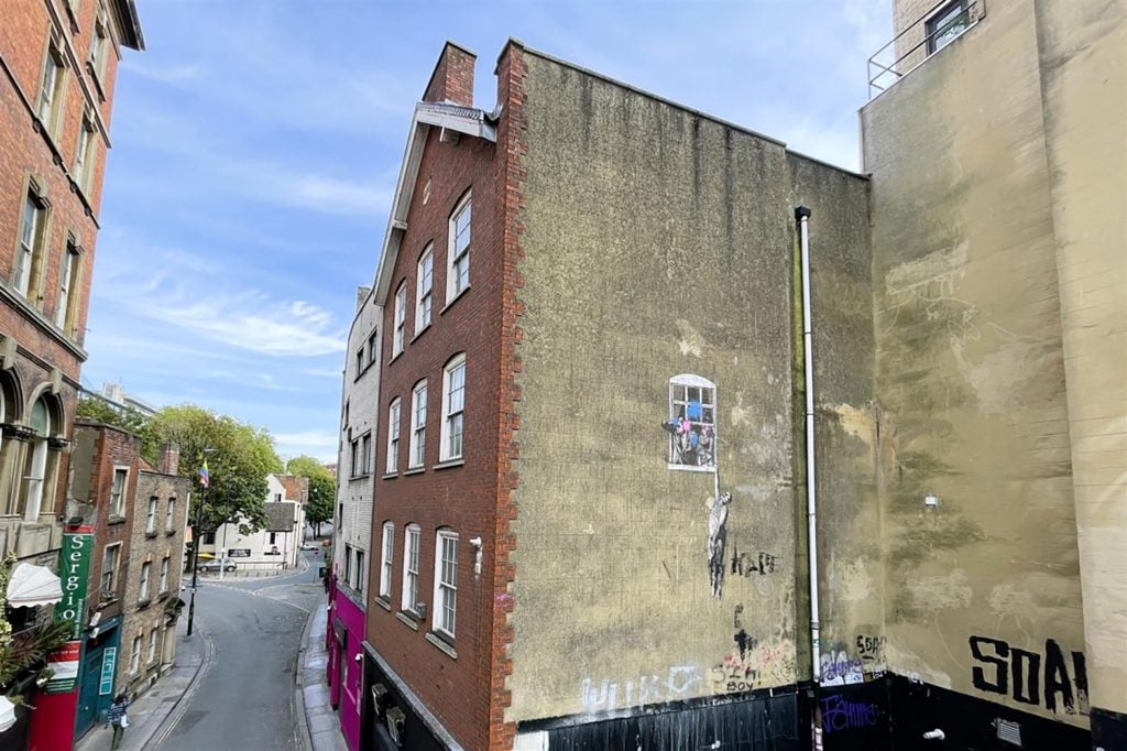 A Bristol building featuring Banksy's 'Well Hung Lover'