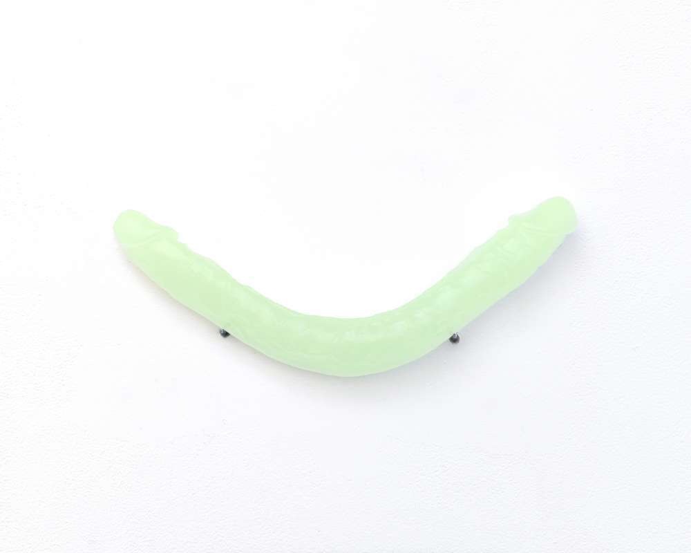 A photograph of a phosopherescent polyeurethane cast of Benglis' "Ghost of Smile," depicted on a plain white background.