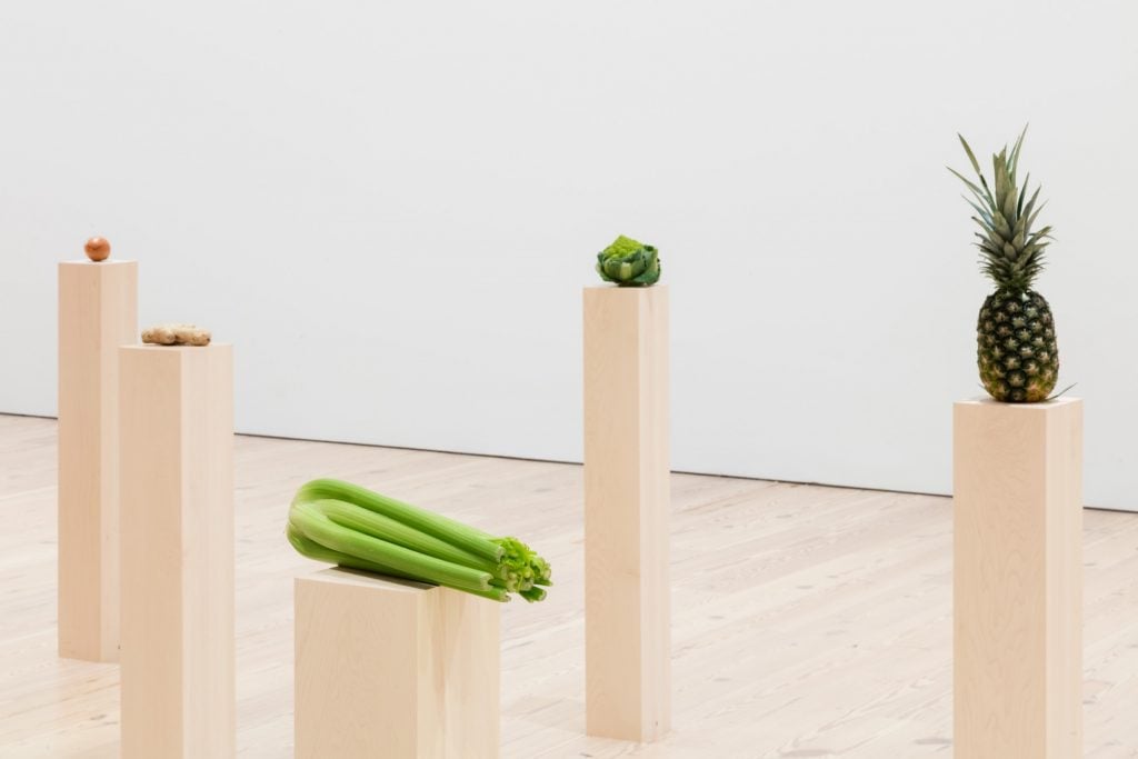 Fruits and vegetables sitting on top of display plinths