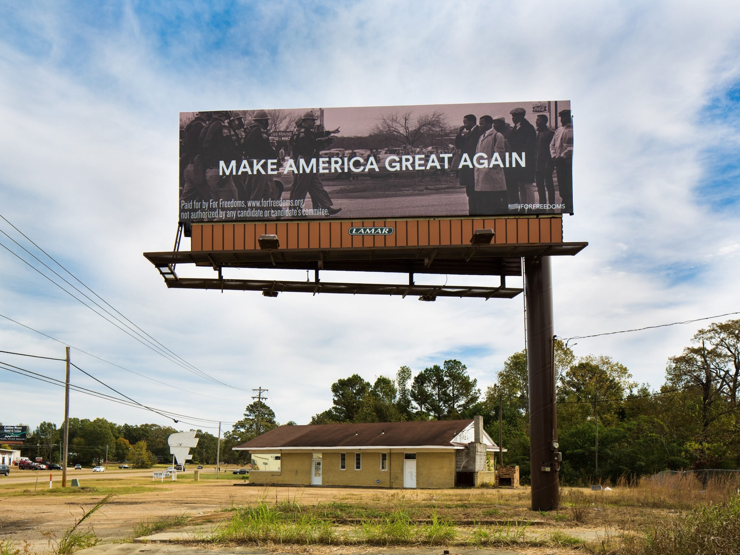 A billboard in a rural area reading "Make America Great Again"