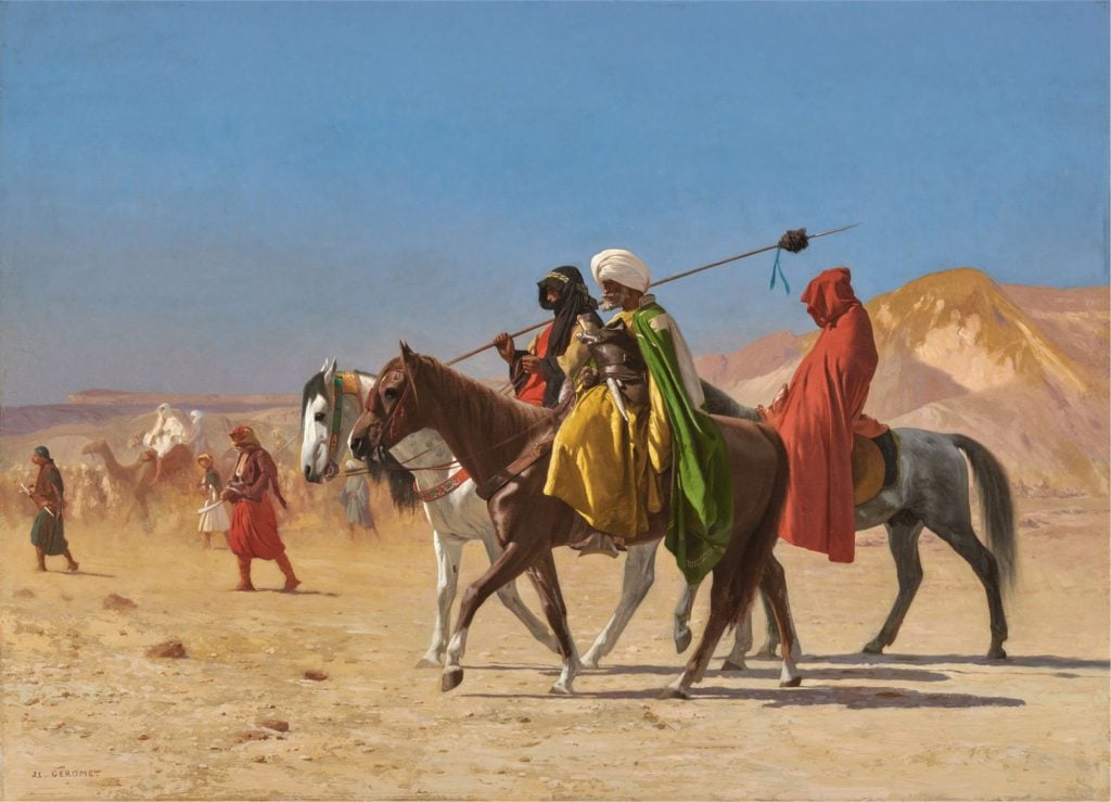 Jean-Léon Gérôme painting depicting a group of brightly dressed riders crossing a dessert under a blue sky and endless stretch of sand.