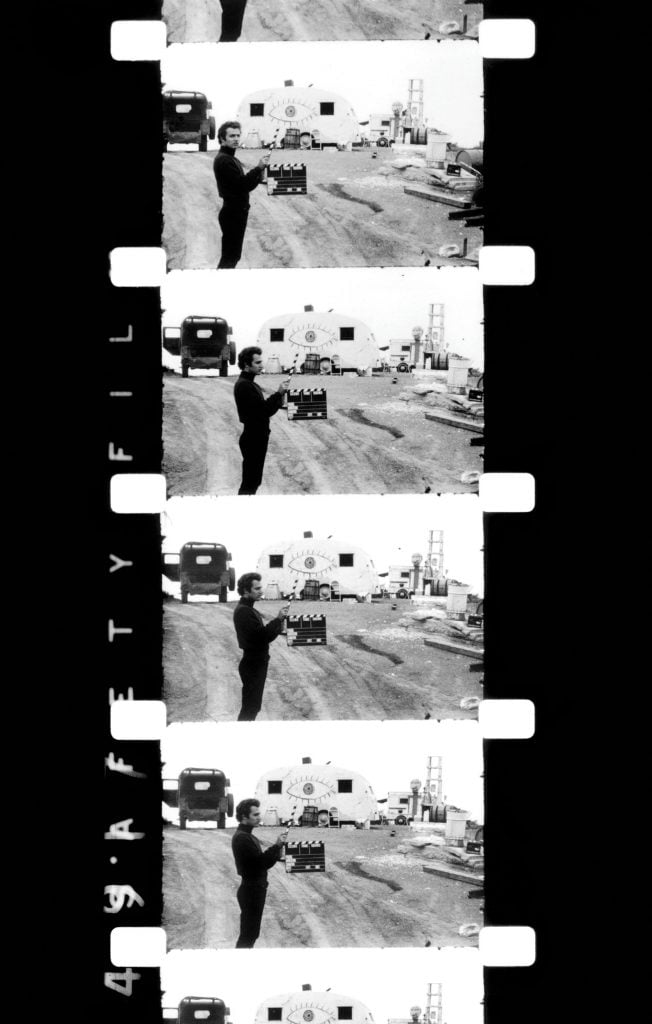 Film cells showing a man holding a movie clap board