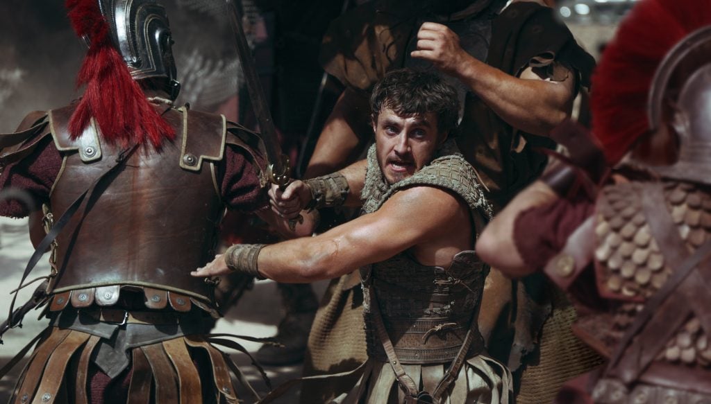 A film still of Paul Mescal in a crowded action scene during Gladiator II.