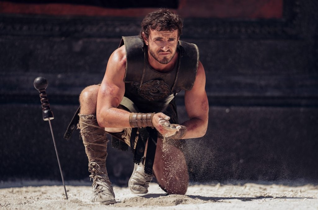 A film still depicting Paul Mescal crouched in the arena during Gladiator II.