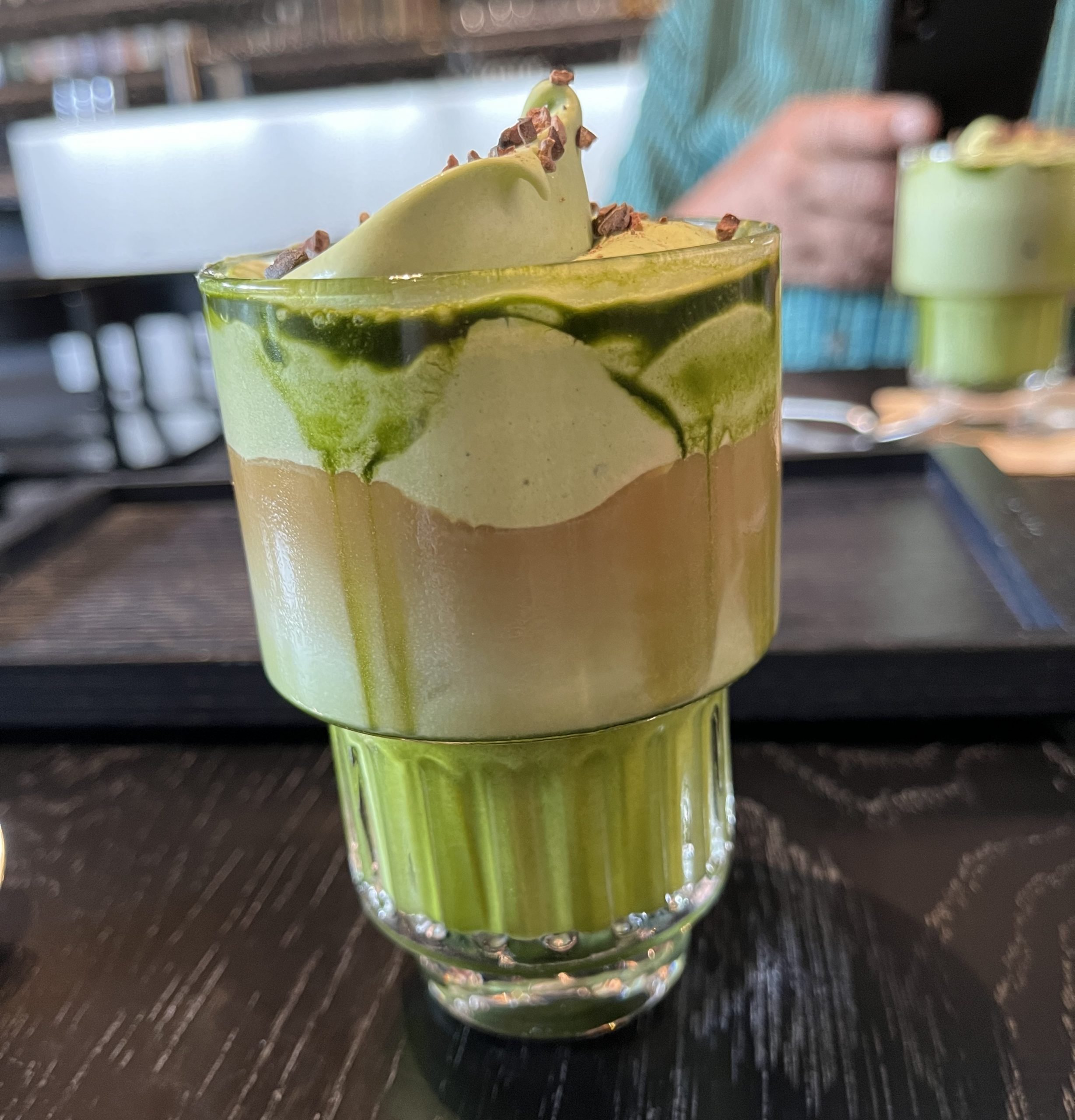 A glass filled with a green beverage