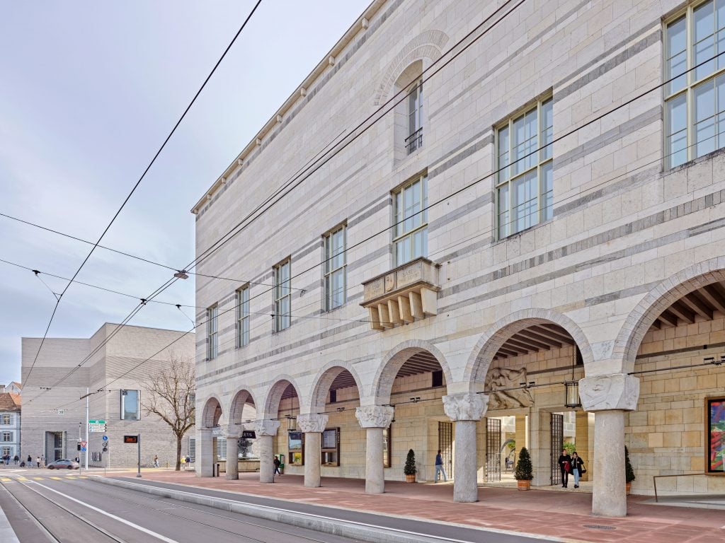 Exterior view of Kunstmuseum Basel in Switzerland, showing its historic stone arches and modern extension.